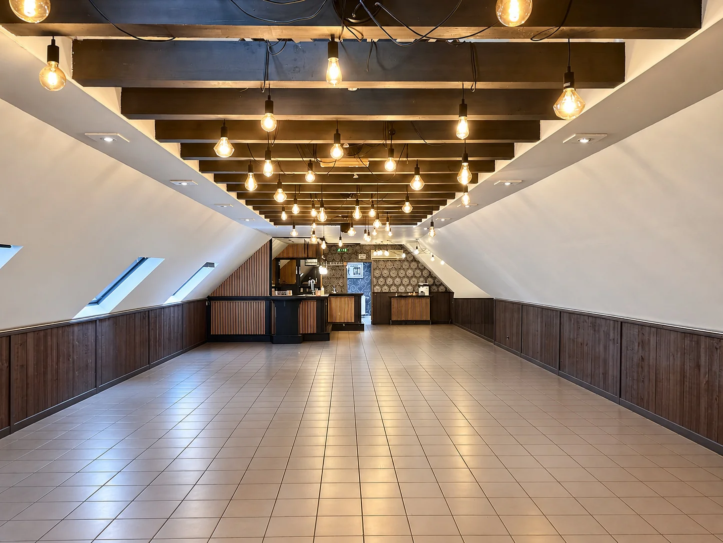 La seconde salle sous la charpente, avec son bar au fond